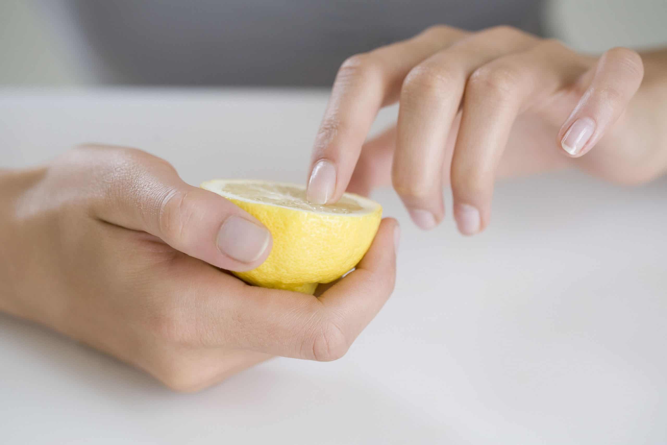 woman whitening her fingernails with a lemon
